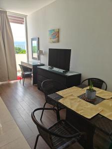 Nice and comfy appartment at Playa Blanca Beach Resort Trown Center في Río Hato: غرفة معيشة مع طاولة ومكتب مع تلفزيون