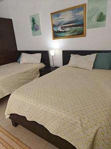 Nice and comfy appartment at Playa Blanca Beach Resort Trown Center في Río Hato: غرفة نوم بها سريرين ولوحة على الحائط +8 صور