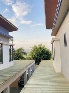 a wooden walkway between two houses with a car on it at Eddie Homes Rwanda in Kigali