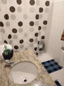 Un baño con lavabo y una pared de lunares. en Studio, en Río de Janeiro
