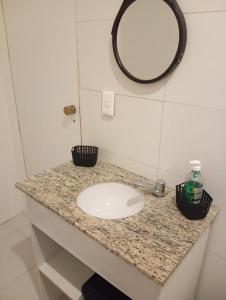 Un mostrador de baño con un lavabo y un espejo. en Studio, en Río de Janeiro 8 fotos más