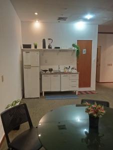 una cocina con mesa y una cocina con refrigerador en Studio, en Río de Janeiro
