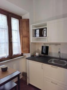 a small kitchen with a sink and a microwave at La casa di Fannie in Arezzo +10 photos