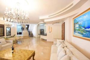 una sala de estar con un sofá y una mesa en Kfar Vradim Nature Escape, en Kefar Weradim