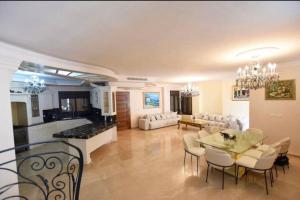 Una gran sala de estar con mesa y sillas. en Kfar Vradim Nature Escape, en Kefar Weradim