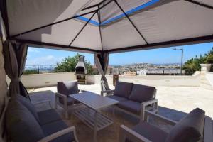 Un patio con sillas y una mesa y una vista. en Kfar Vradim Nature Escape, en Kefar Weradim