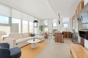 een woonkamer met een bank en een tafel bij Ocean Vista Aruba in Palm-Eagle Beach