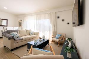 a living room with a couch and a table at Cozy 2BD Condo, Near Beach in San Felipe de Puerto Plata