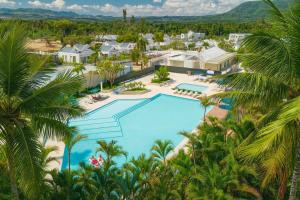 an aerial view of a resort with a pool and palm trees at Cozy 2BD Condo, Near Beach in San Felipe de Puerto Plata