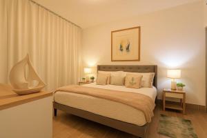 a bedroom with a large bed with two night stands and two lamps at Cozy 2BD Condo, Near Beach in San Felipe de Puerto Plata +38 photos