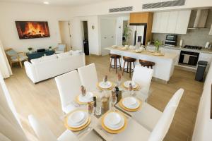 a kitchen and living room with a table and chairs at Cozy 2BD Condo, Near Beach in San Felipe de Puerto Plata