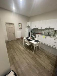 Cost Effective Stay in Core Downtown Queen-King St-Self Checkin & Free Wifi في تورونتو: مطبخ مع دواليب بيضاء وطاولة مع كراسي