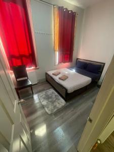 Cost Effective Stay in Core Downtown Queen-King St-Self Checkin & Free Wifi في تورونتو: غرفة نوم بسرير ونافذة ذات ستائر حمراء