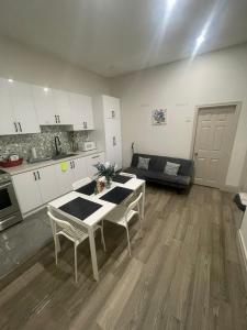 Cost Effective Stay in Core Downtown Queen-King St-Self Checkin & Free Wifi في تورونتو: مطبخ وغرفة معيشة مع طاولة وكراسي