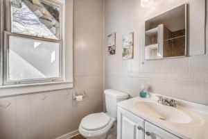 a bathroom with a toilet and a sink and a window at The Clearview Hideaway - Cozy in Memphis