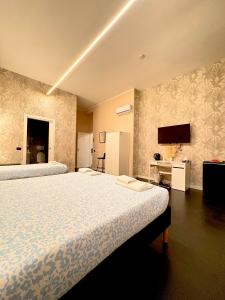 a bedroom with two beds and a tv on the wall at The Central Rock Inn camere con bagno privato self check in in Piacenza
