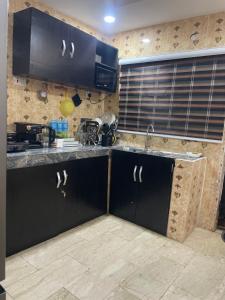 a kitchen with black cabinets and a counter top at Serenity By Mayor in Iranla