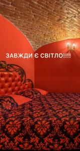 ein Bett in einem Zimmer mit einer roten Wand in der Unterkunft Apartment Masoch Style in Lwiw