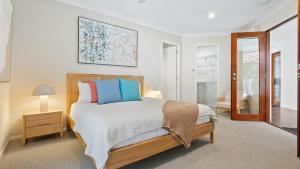 een slaapkamer met een bed met blauwe en rode kussens bij Shambala at Palm Cove in Palm Beach