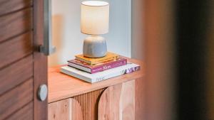 een lamp die bovenop boeken op een tafel zit bij Shambala at Palm Cove in Palm Beach
