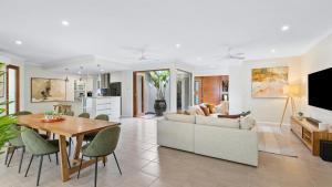 een woonkamer met een bank en een tafel bij Shambala at Palm Cove in Palm Beach +39 foto's