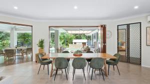 een eetkamer met een tafel en stoelen bij Shambala at Palm Cove in Palm Beach