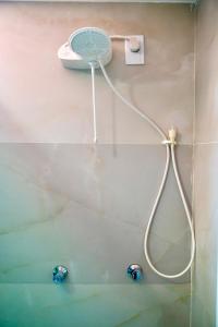 una ducha con una manguera fijada a una pared en Pousada Sousa Residencial Qrt2, en Sousa