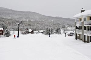a person on a ski lift in the snow at Hameau 28-41 studio in Stoneham
