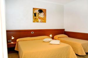 Zimmer mit 2 Betten und Wandgemälde in der Unterkunft Hotel Giacomazzo in Caorle