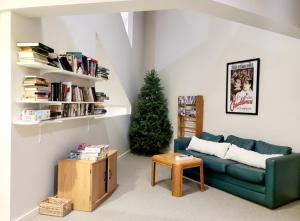 a living room with a green couch and a christmas tree at Magic Mountain Ski Resort in Londonderry