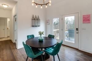 a dining room with a table and green chairs at Hot Tub and Yard Temptation Stays Home in Roanoke in Cave Spring