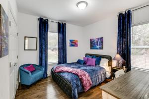 a bedroom with a bed and a blue chair at Hot Tub and Yard Temptation Stays Home in Roanoke in Cave Spring