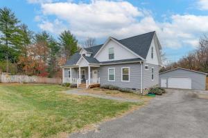 a white house with a driveway in a yard at Hot Tub and Yard Temptation Stays Home in Roanoke in Cave Spring
