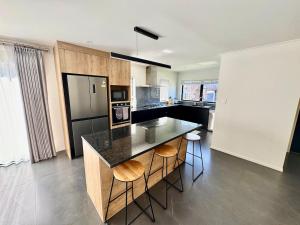 a kitchen with a counter and a black refrigerator at New 4BR Family Home in Greenhill Park, Chartwell in Hamilton +34 photos