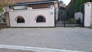 a house with a black gate and a brick driveway at Josephine Apartment in Subotica