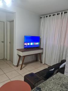 a laptop sitting on a table in a living room at Belo Apto ao lado do Shopping in Franca