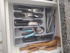 a drawer full of utensils in a cabinet at Belo Apto ao lado do Shopping in Franca
