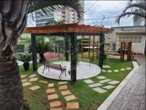 a bench sitting under a pavilion in a park at Belo Apto ao lado do Shopping in Franca