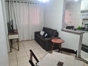 a living room with a couch and a table at Belo Apto ao lado do Shopping in Franca +15 photos