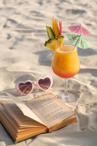 White Cottage Boutique Guesthouse في سواكوبموند: كتاب مفتوح وكأس من عصير البرتقال وكتاب