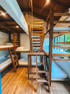 une chaise en bois dans une chambre avec des lits superposés dans l'établissement Sea Wolf Surf Hostel Campeche, à Florianópolis