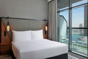 a bed in a hotel room with a large window at The First Collection Waterfront, Dubai, a Tribute Portfolio Hotel in Dubai +32 photos