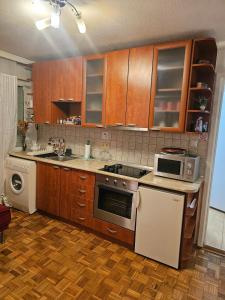 a kitchen with wooden cabinets and a stove top oven at Happy apartment-OldTown Sarajevo in Sarajevo +14 photos