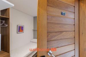 サンパウロにあるApto na Bela Vista Perto do Hospital Sirio Libanesのベッドルームの木製ドア(ベッド付)