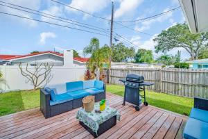 a patio with a blue couch and a grill on a deck at Heated Pool Family Fun at Silver Sands Clearwater in Clearwater