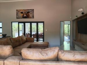 Eagle's Retreat في مارلوث بارك: غرفة معيشة مع أريكة وتلفزيون بشاشة مسطحة