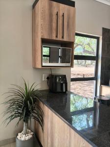 Eagle's Retreat في مارلوث بارك: مطبخ مع كونتر توب مع ميكروويف