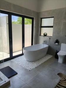 Eagle's Retreat في مارلوث بارك: حمام كبير مع حوض استحمام ومرحاض