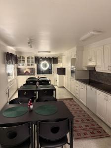 een keuken met witte kasten en tafels en stoelen bij Nietos Aurora in Ylitornio