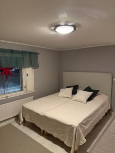 een slaapkamer met een bed met een raam en een witte sprei bij Nietos Aurora in Ylitornio